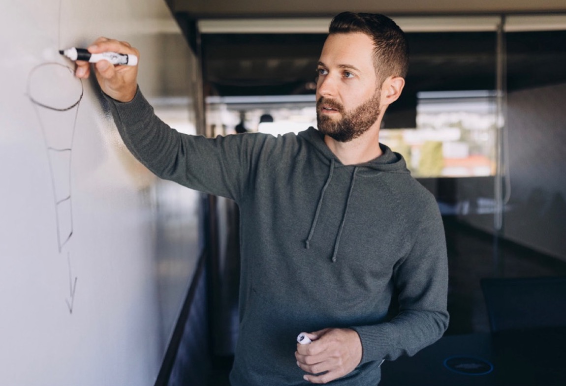 Jordan Godbey drawing a diagram on a whiteboard